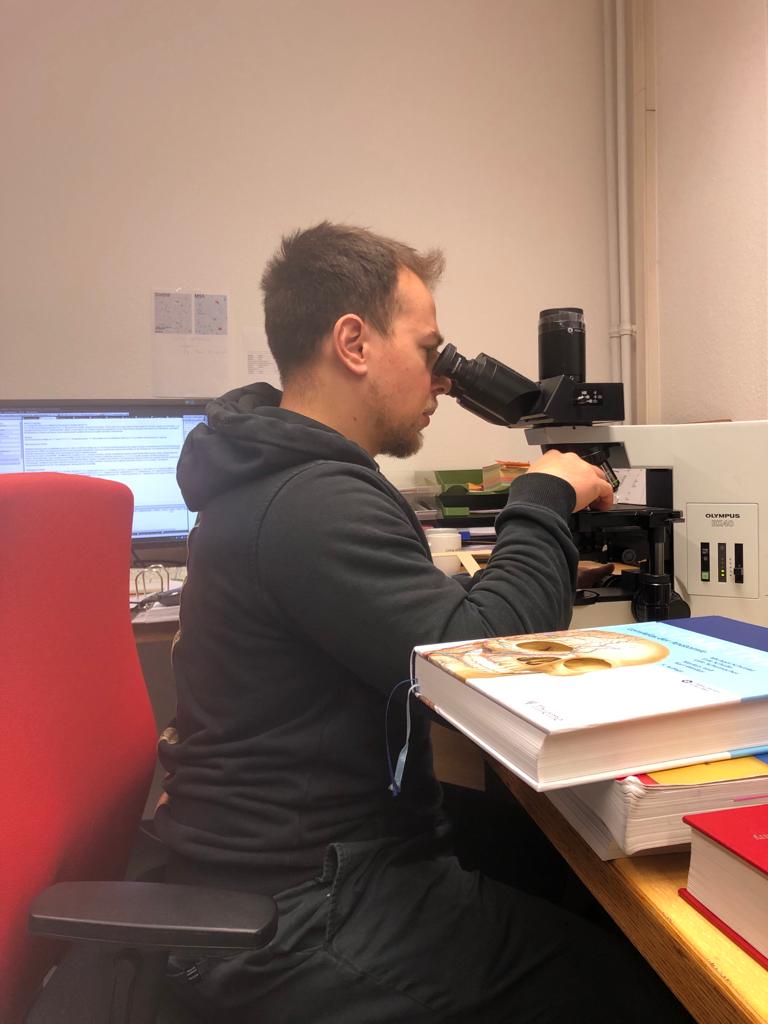 Deniz Tafrali am Mikroskop in der Neuropathologie Tübingen